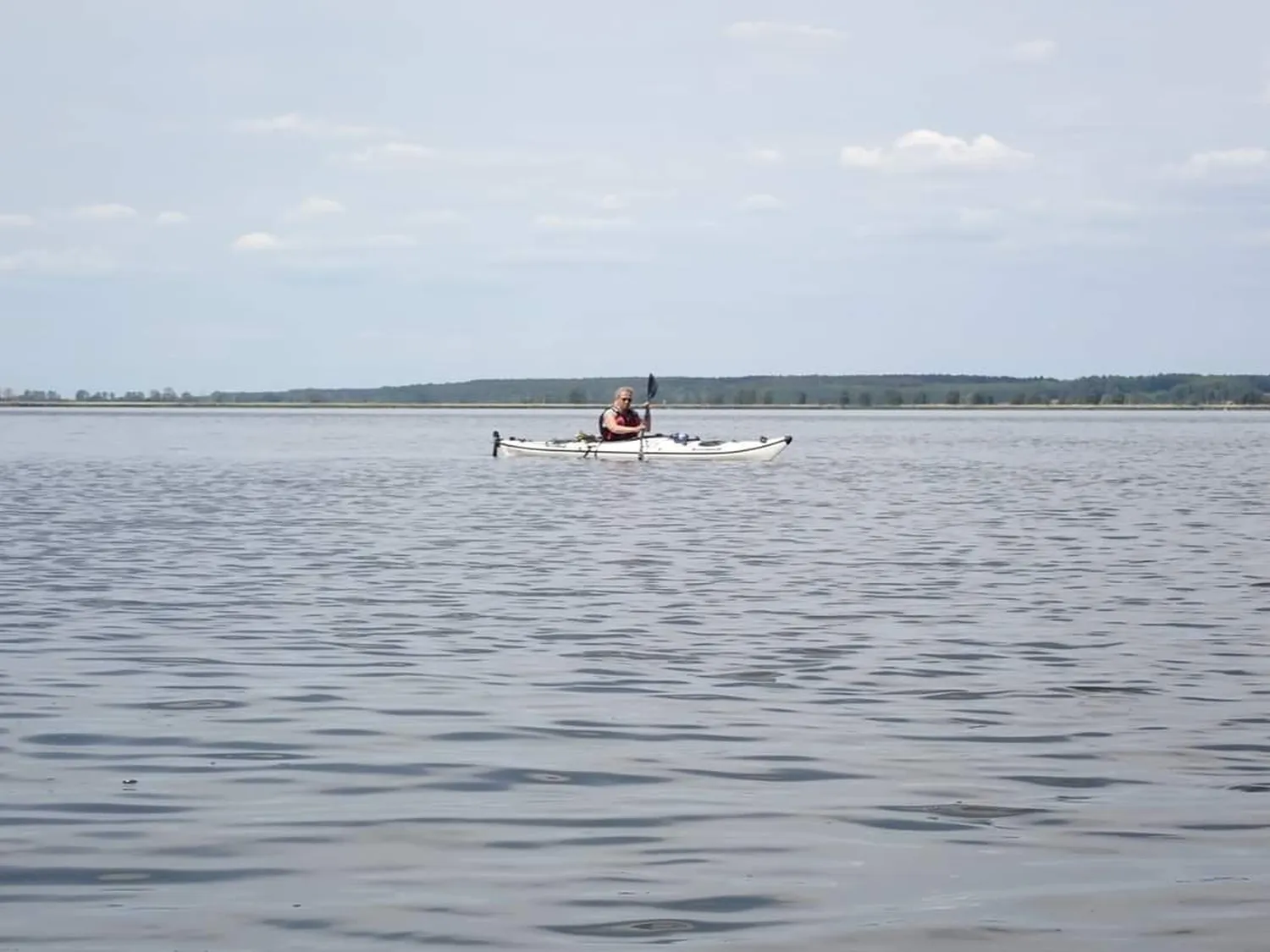 Eine Person rudert mit einem Boot im See